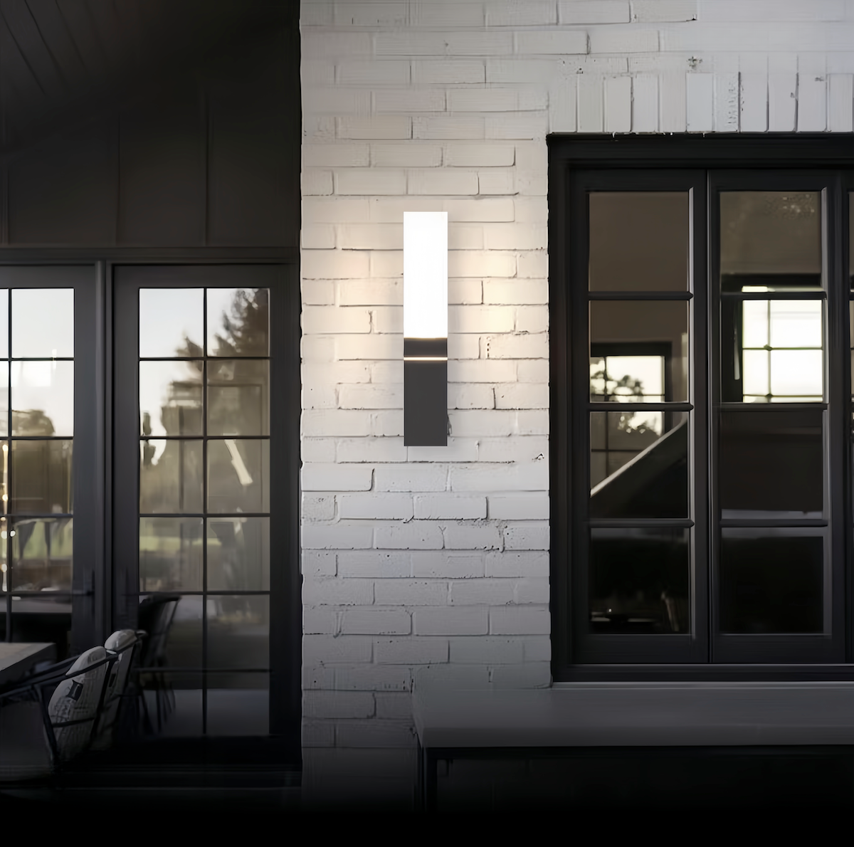 Modern outdoor wall light with a white brick wall and glass doors.