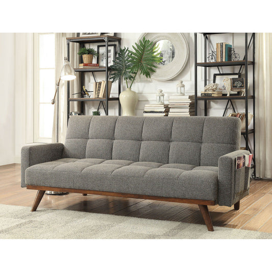 Gray futon sofa with tufted linen, angled wooden legs, and side pockets in a modern living room setting.