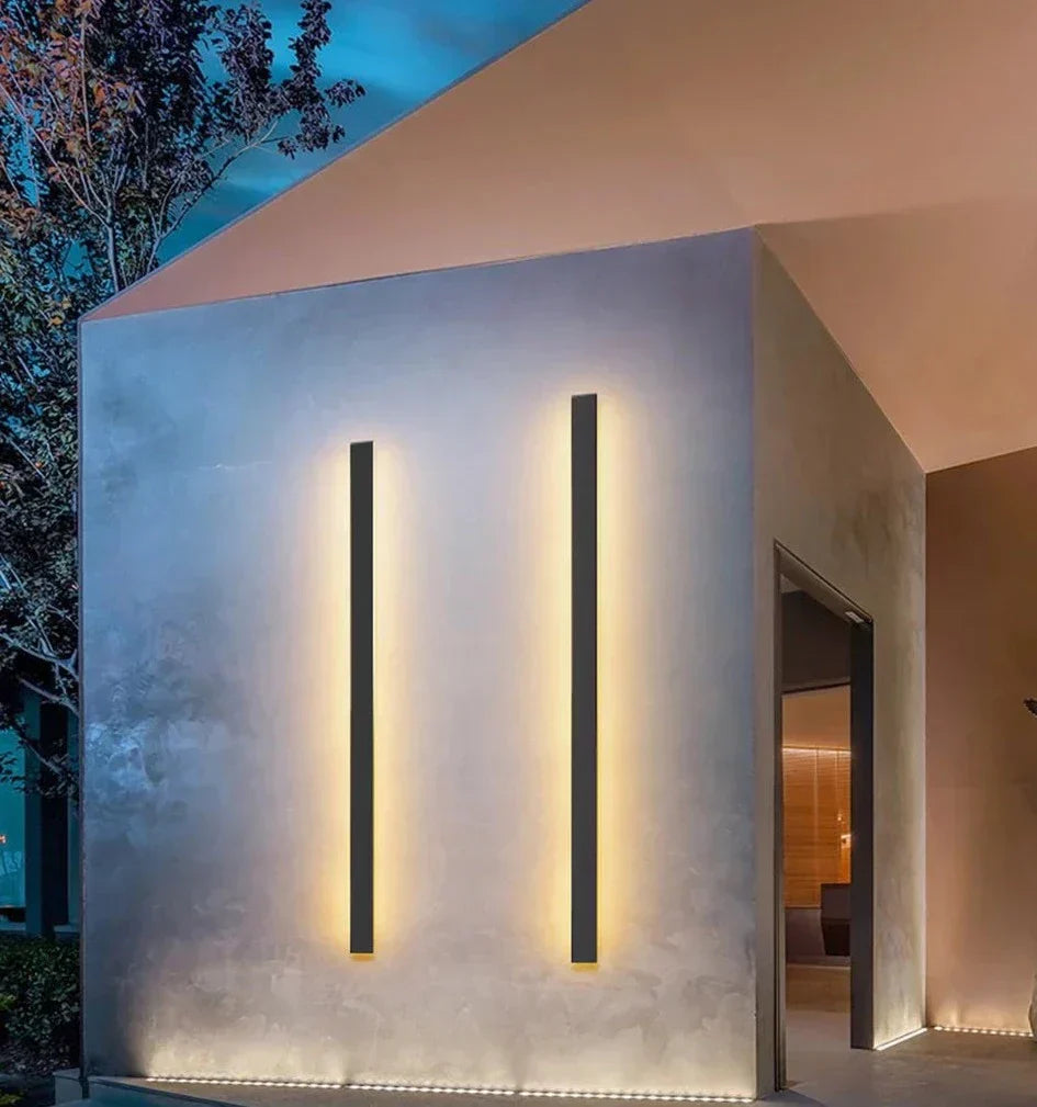 Waterproof IP65 outdoor wall light illuminating a modern building exterior.