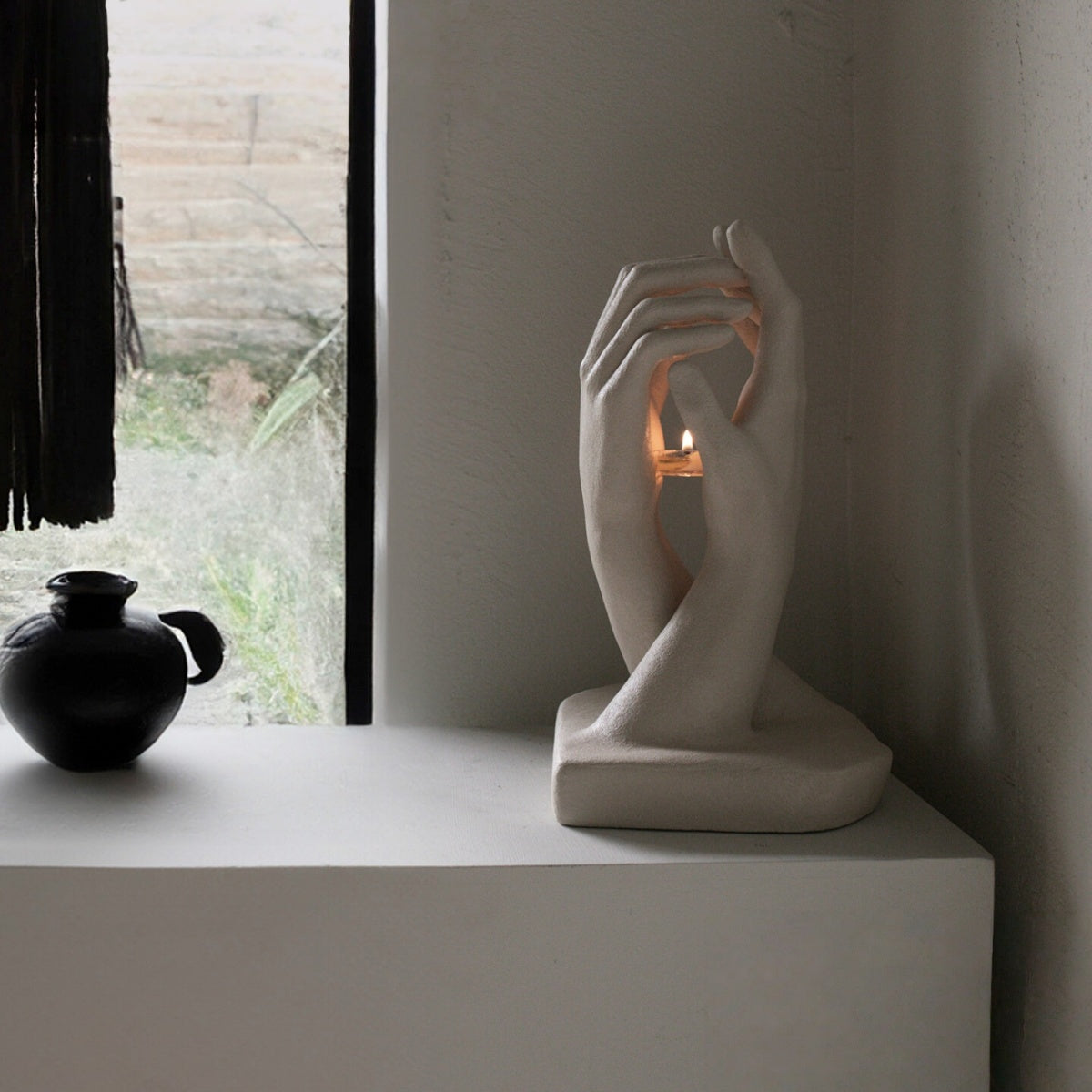 Handmade creative candlestick with two sculptural hands reaching toward each other in vintage art style