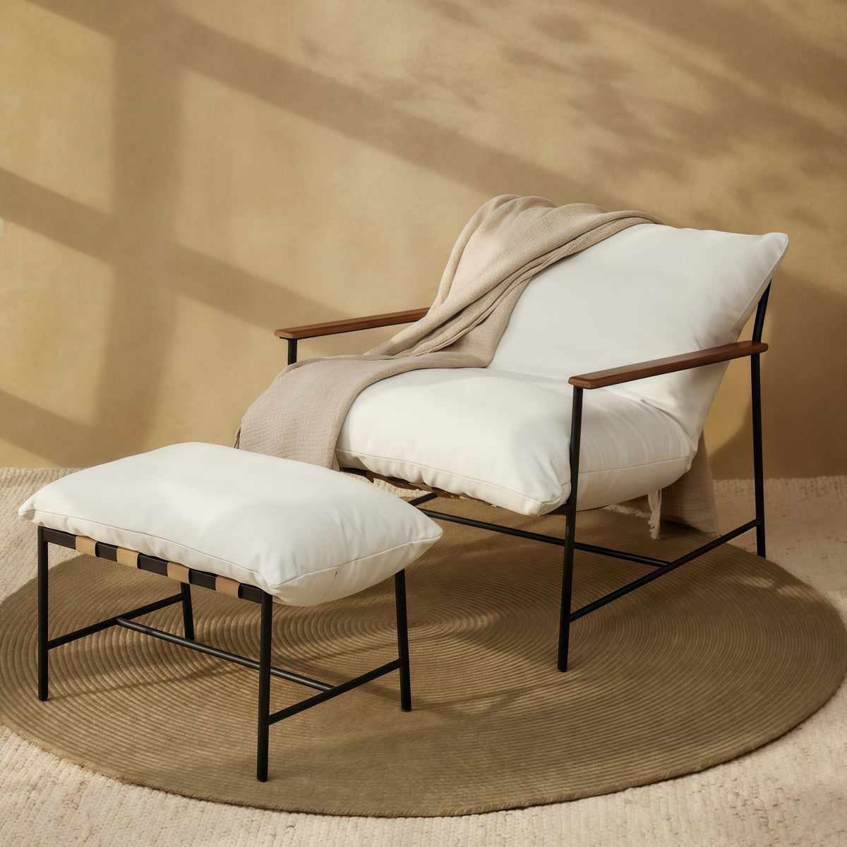 Vail Lounge Chair with stool featuring plush feather-blend cushion, black steel frame, leather straps, and felt gliders