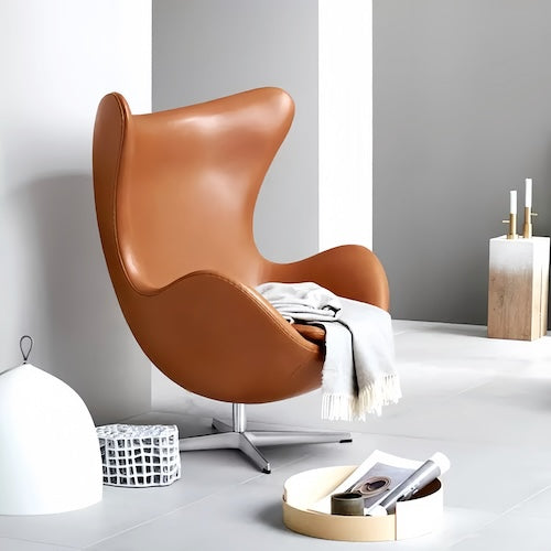 Egg Chair Replica with stool in brown leather and sleek metal base, modern interior design.