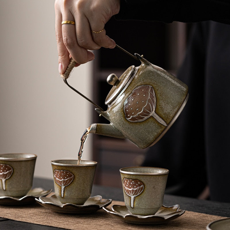 Exquisite ceramic teapot pouring tea into matching cups, part of a charming tea gift set.