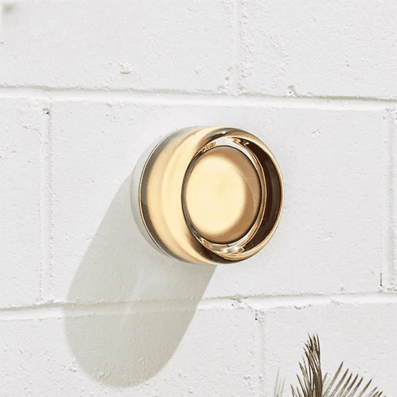 Wall sconce lighting with warm light on white brick wall, perfect for various spaces.