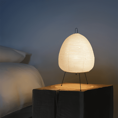 Traditional Japanese rice paper lamp on a wooden table, illuminating a cozy room - motivodecor.com