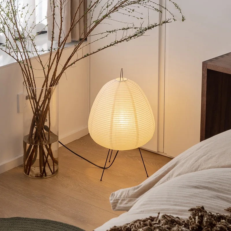 Rice paper lamp with traditional Japanese design on wooden frame, illuminating a modern room.