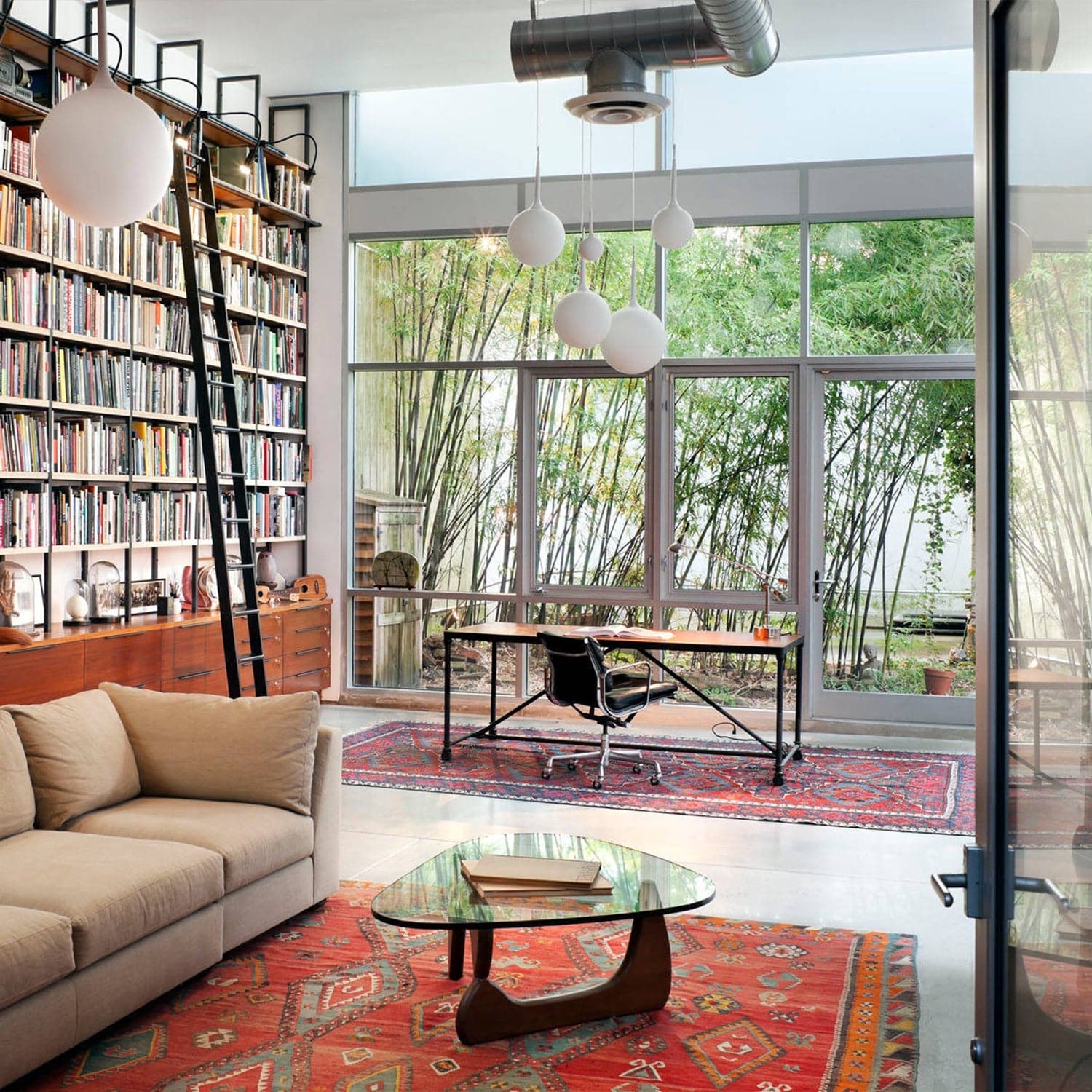 Noguchi Coffee Table in modern living space with bookshelf and large windows - motivodecor.com