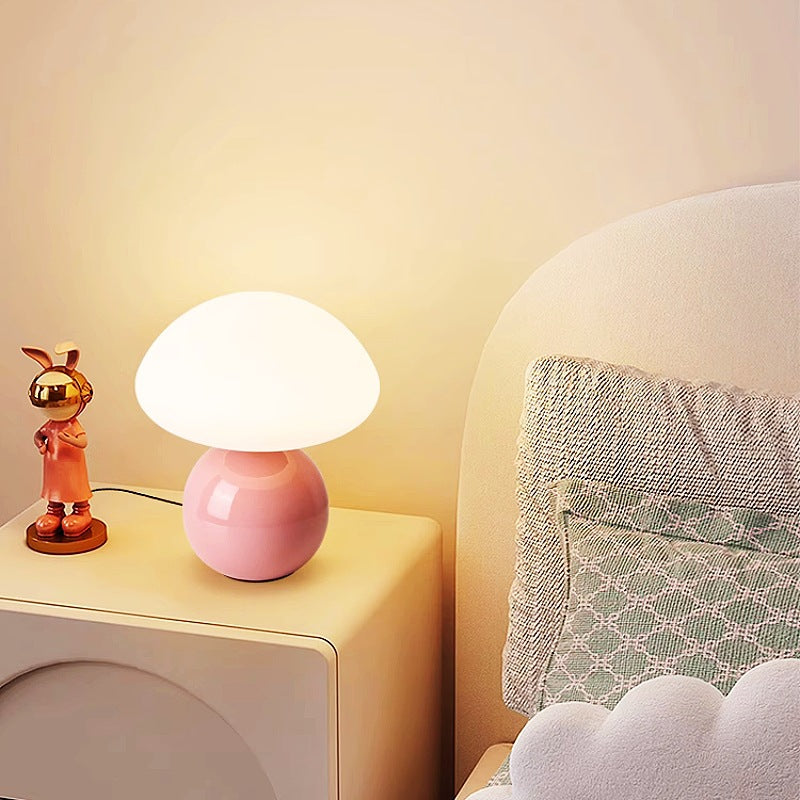 Ceramic table lamp with mushroom shape on bedside, offering cozy ambiance and warm illumination.