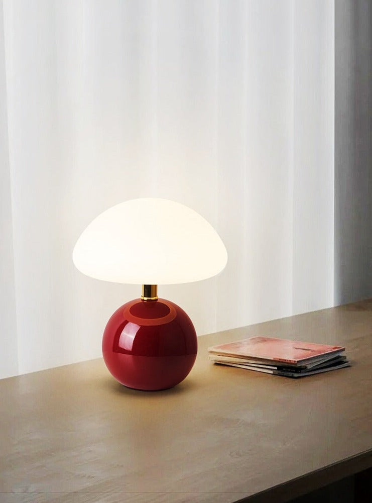 Ceramic table lamp with mushroom shape and LED light on a wooden table.