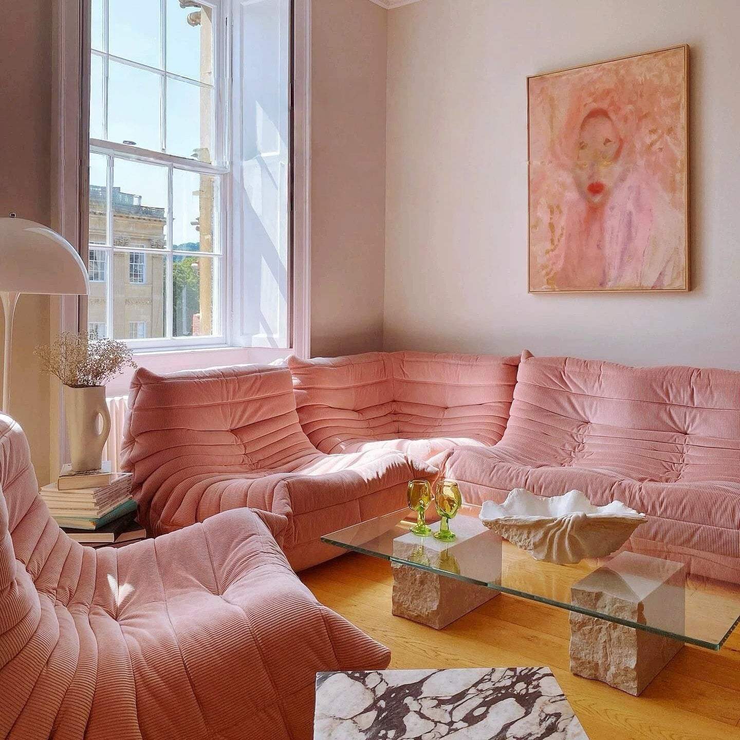 Pink upholstered togo sofa set - 5 pieces in a living room with a painting on the wall.