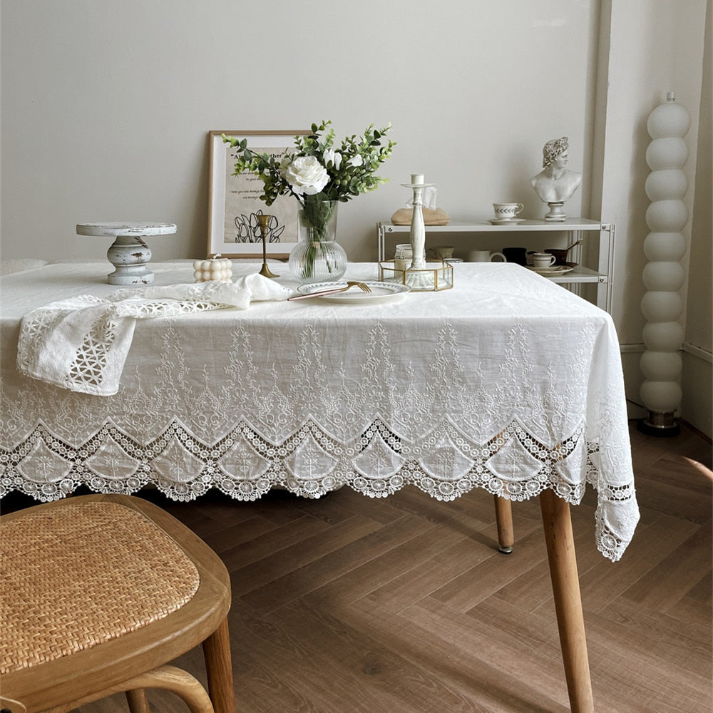 Handmade white tablecloth with embroidered patterns on a table setting, 100% cotton, ideal for weddings and gatherings.