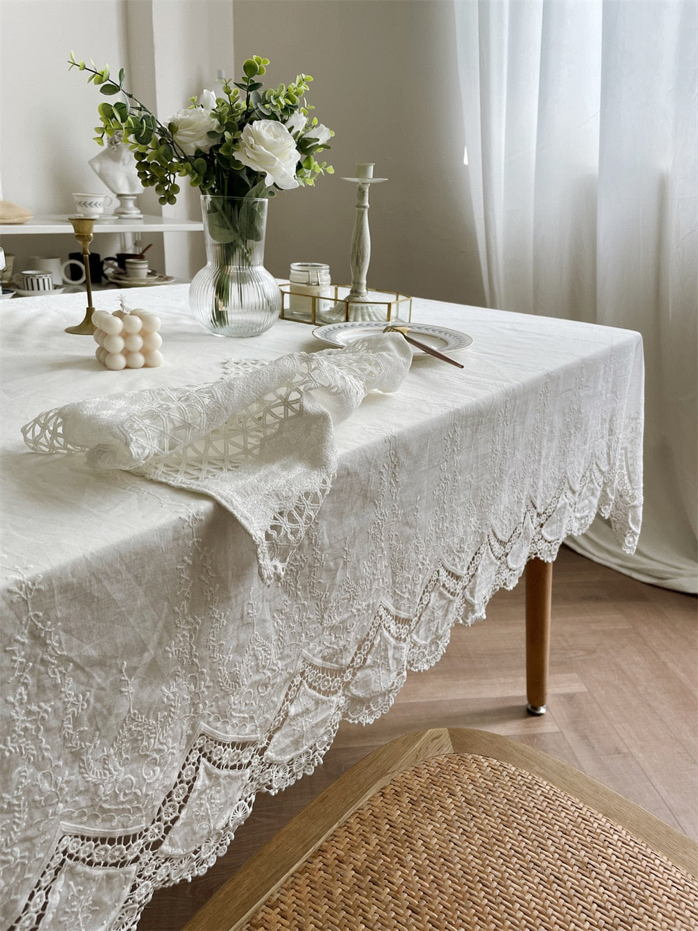 Handmade white tablecloth with intricate embroidery on a dining table, crafted from 100% cotton for elegance and versatility.