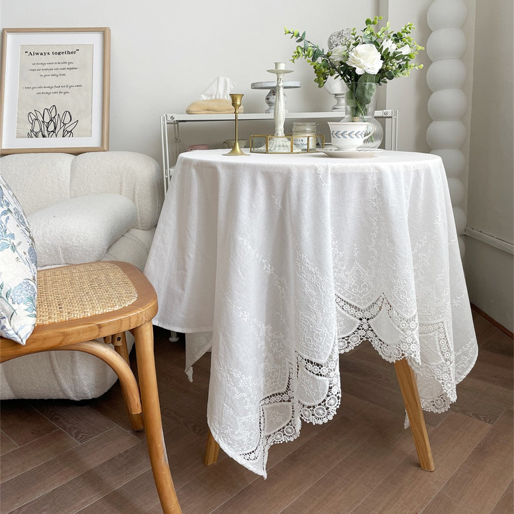 Handmade white tablecloth with intricate embroidery on dining table.