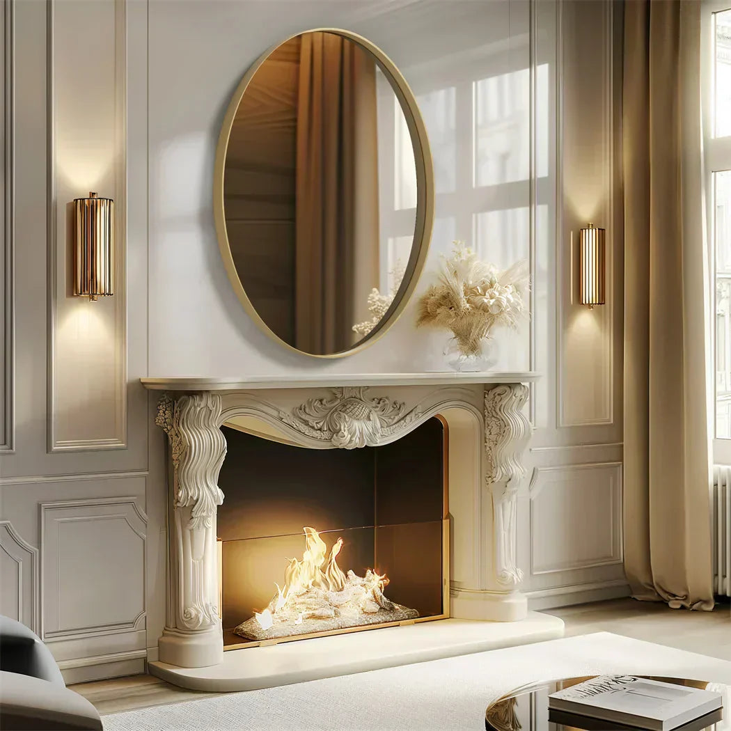 Elegant oval vanity mirror with brushed gold aluminum frame, enhancing living room decor above a fireplace.