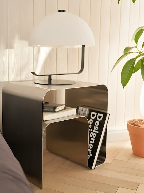 Minimalist stainless steel lounge side table in modern living room setting.