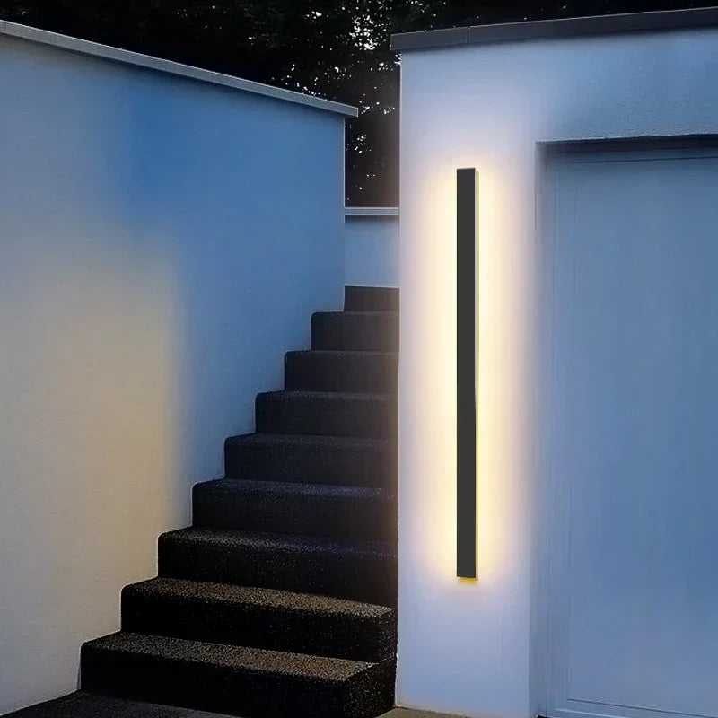 Waterproof IP65 outdoor wall light illuminating a modern entrance with sleek black design.