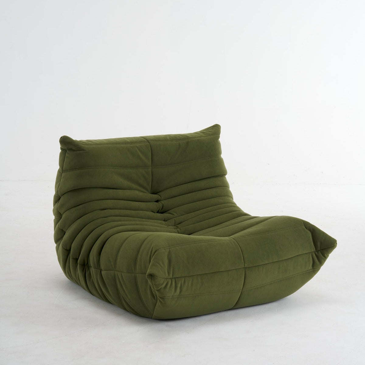An olive green modular lounge chair with a heavily padded, ribbed, and segmented design, photographed against a seamless white studio background.