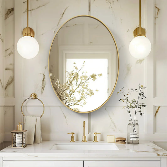 Oval vanity mirror with brushed gold frame in elegant bathroom setting.