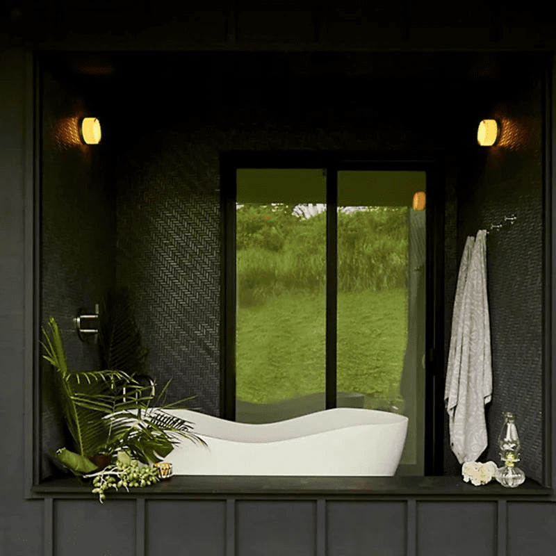 Wall sconce lighting in modern bathroom with outdoor view.