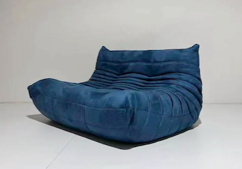 Ligne Roset Togo blue suede sofa with curved cushions and low-profile silhouette.