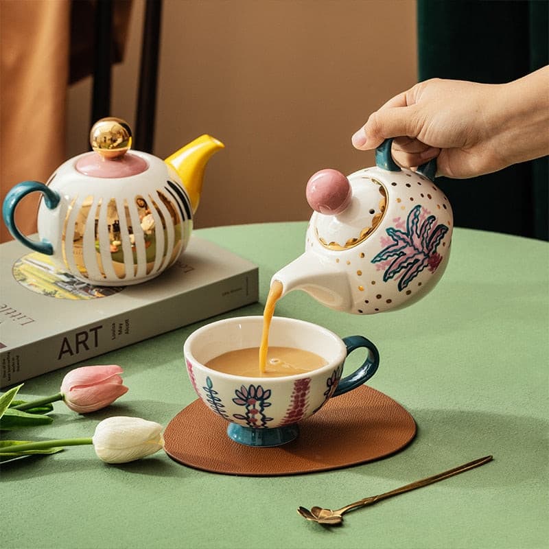 Afternoon tea aesthetic cute ceramic tea set on a table with tulips and a book.