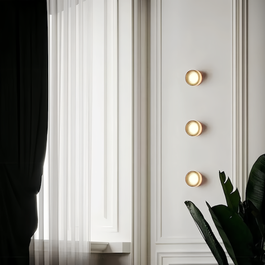 Wall sconce lighting on elegant white panel wall in minimalistic room.