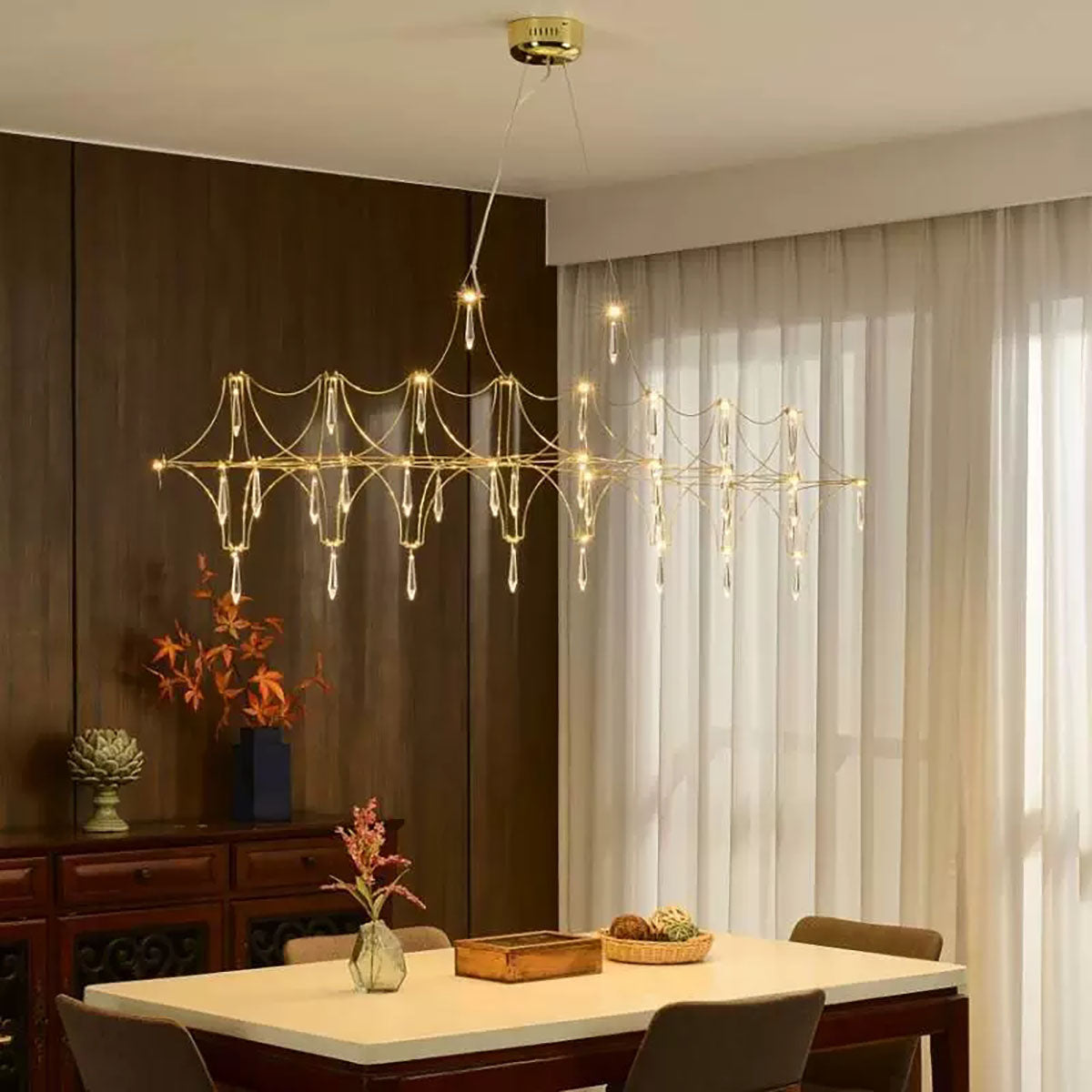 Modern chandelier hanging above a dining table with a neutral color scheme.