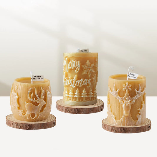 Three decorative candles with Christmas designs on a white background