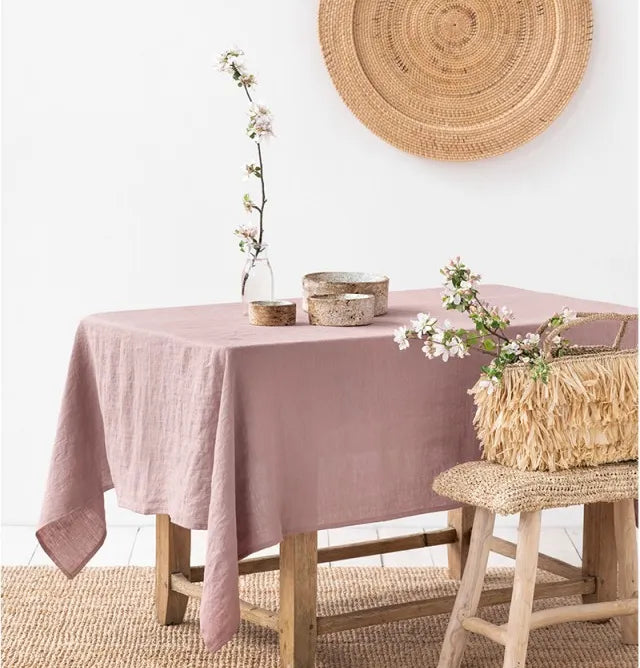 Rectangle tablecloth in pink linen on wooden table with rustic decor.