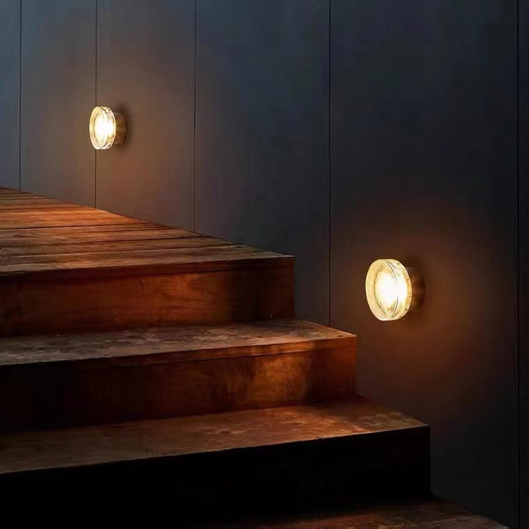 Wall sconce lighting on staircase wall with warm illumination.