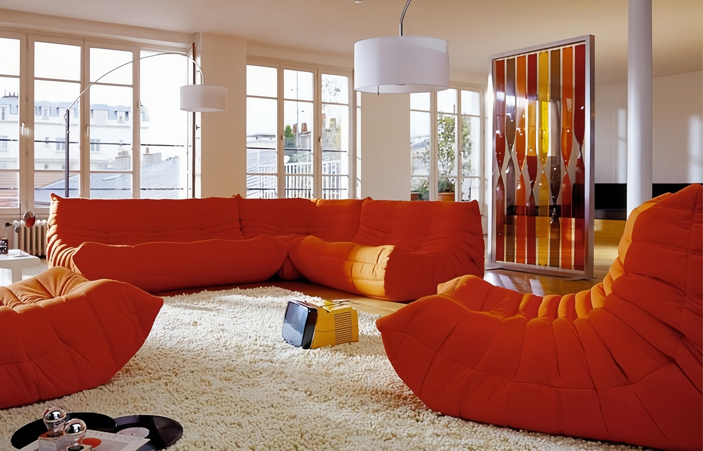 Vibrant orange corduroy Togo sofa set in modern living space.