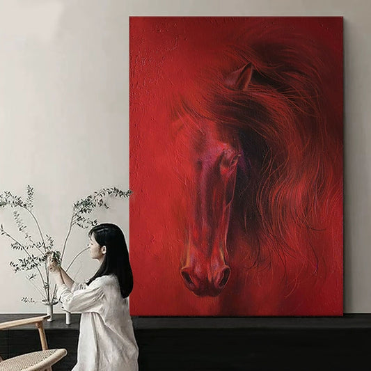Woman sitting in front of a large red painting of a horse in a room with minimal decor.